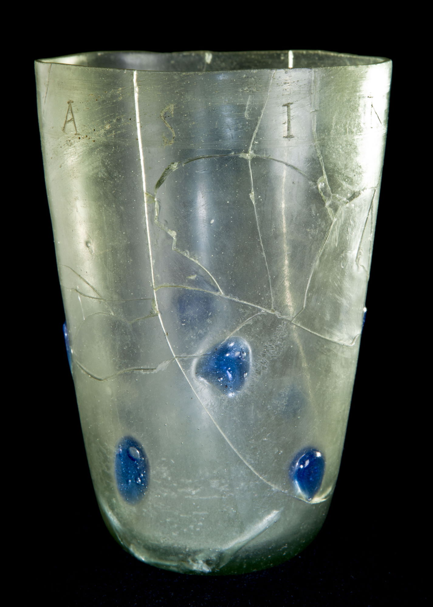 Gobelet en verre orné de pastilles bleues portant une inscription chrétienne © Site et Musée romains d'Avenches, photo NVP3D