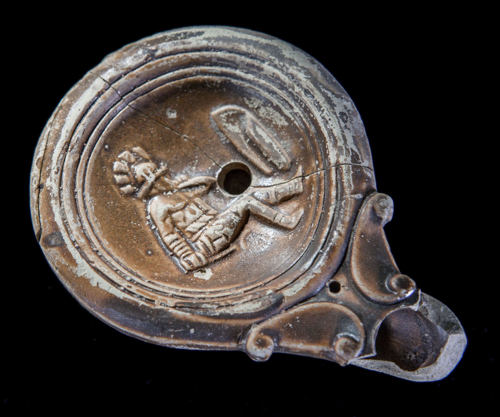 Lampe à huile en terre cuite représentant un gladiateur assis © Site et Musée romains d'Avenches, photo NVP3D