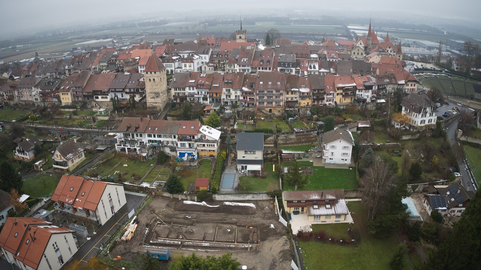 Vue sur le bourg médiéval avec, au premier plan, l'emprise de la fouille