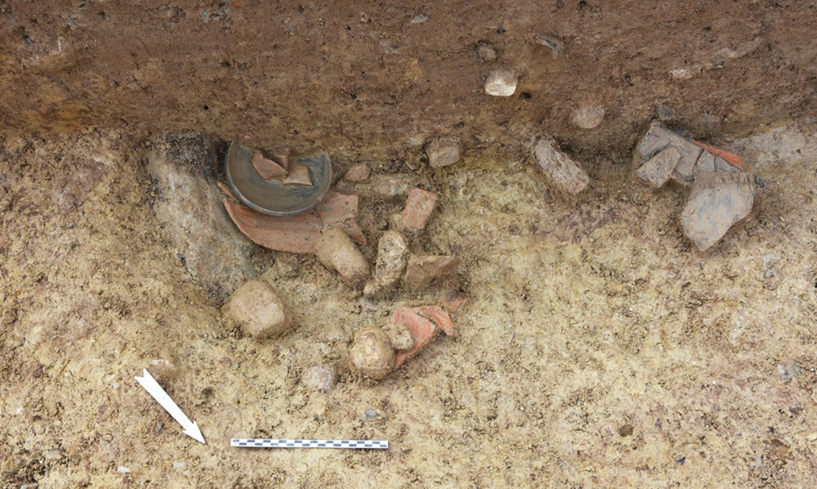 Fosse-dépôt contenant des céramiques peu fragmentées, calées par des pierres