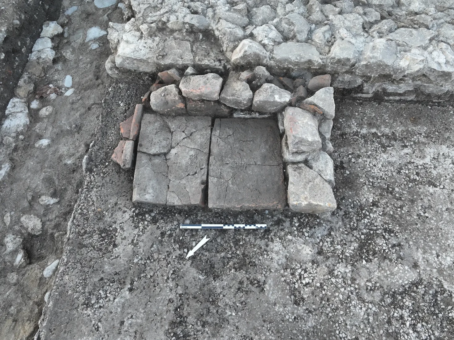 Détail du foyer installé sur le sol en béton et contre le mur