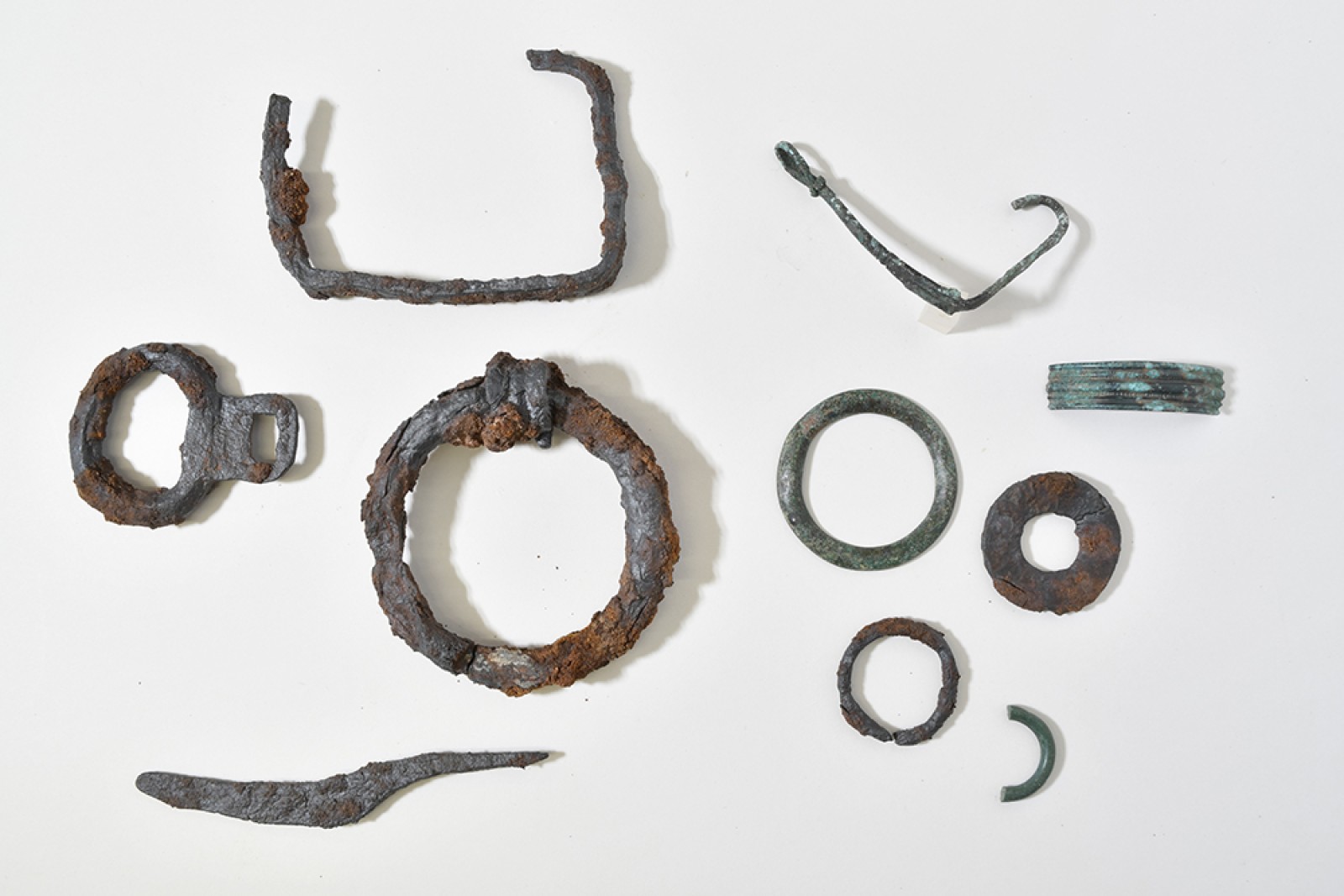 Anse de chaudron, passe-guide, petit rasoir, ébauche de fibule, fragment de bracelet, anneaux et ferrure de la fosse St8
